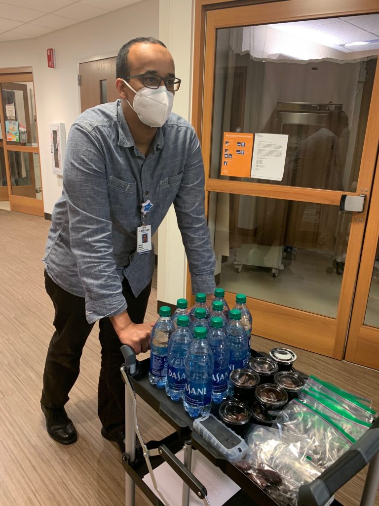 Patient and family services team members passing out food and water during Ramadan