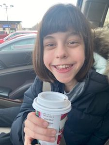Vanessa smiling and holding a Starbucks cup