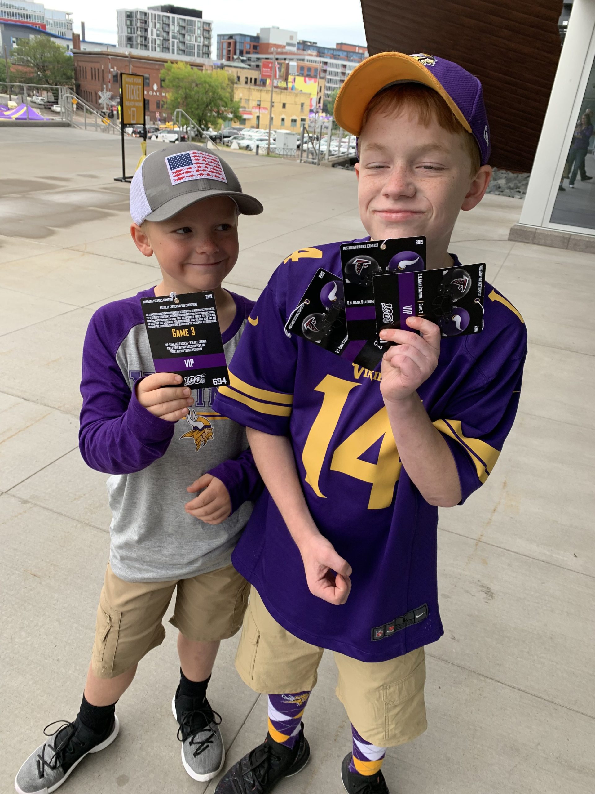 Kaden and his brother outside of the Minnesota Vikings stadium holding up their tickets