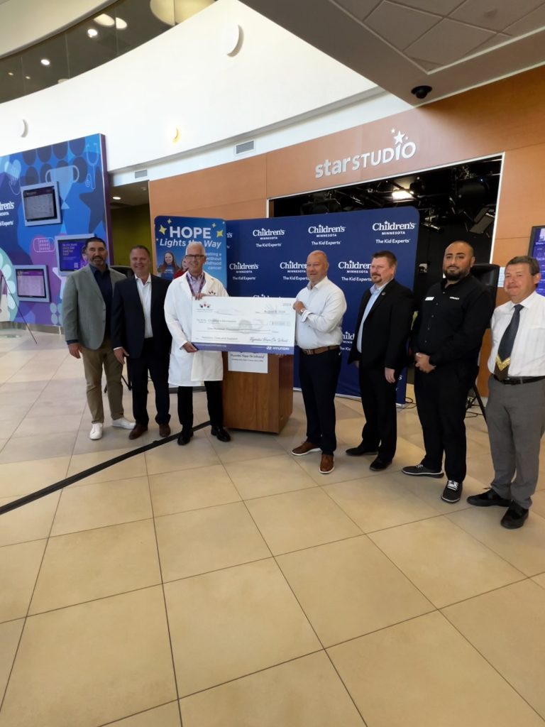 Dr. Richards and Hyundai representatives posing with large grant check.