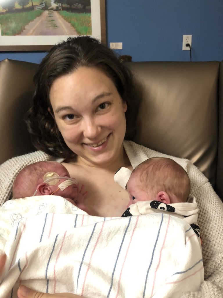 Erin, smiling, with Axel and Barrett in the hospital.