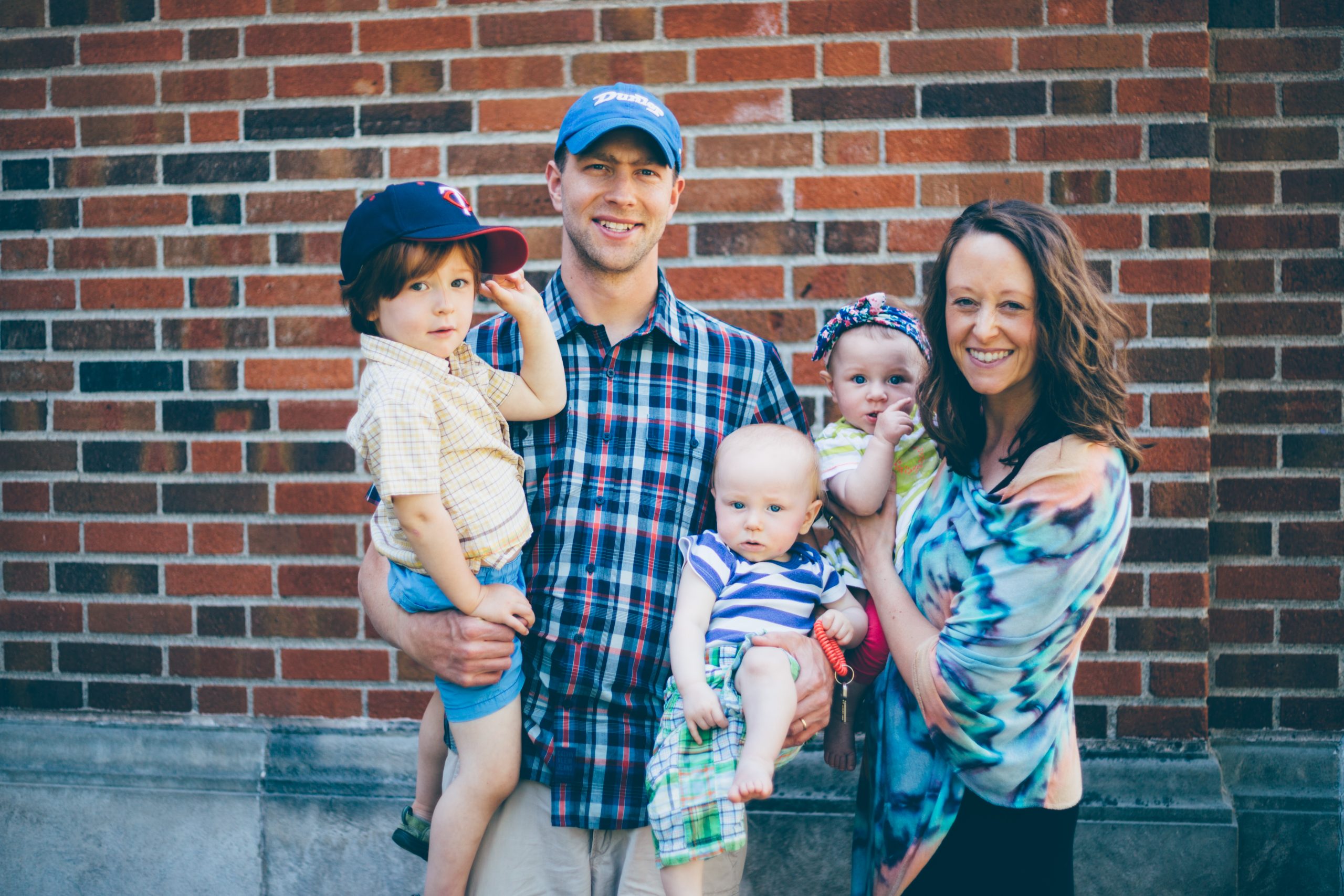 Kelly and Brady's family standing in front of a brick wall