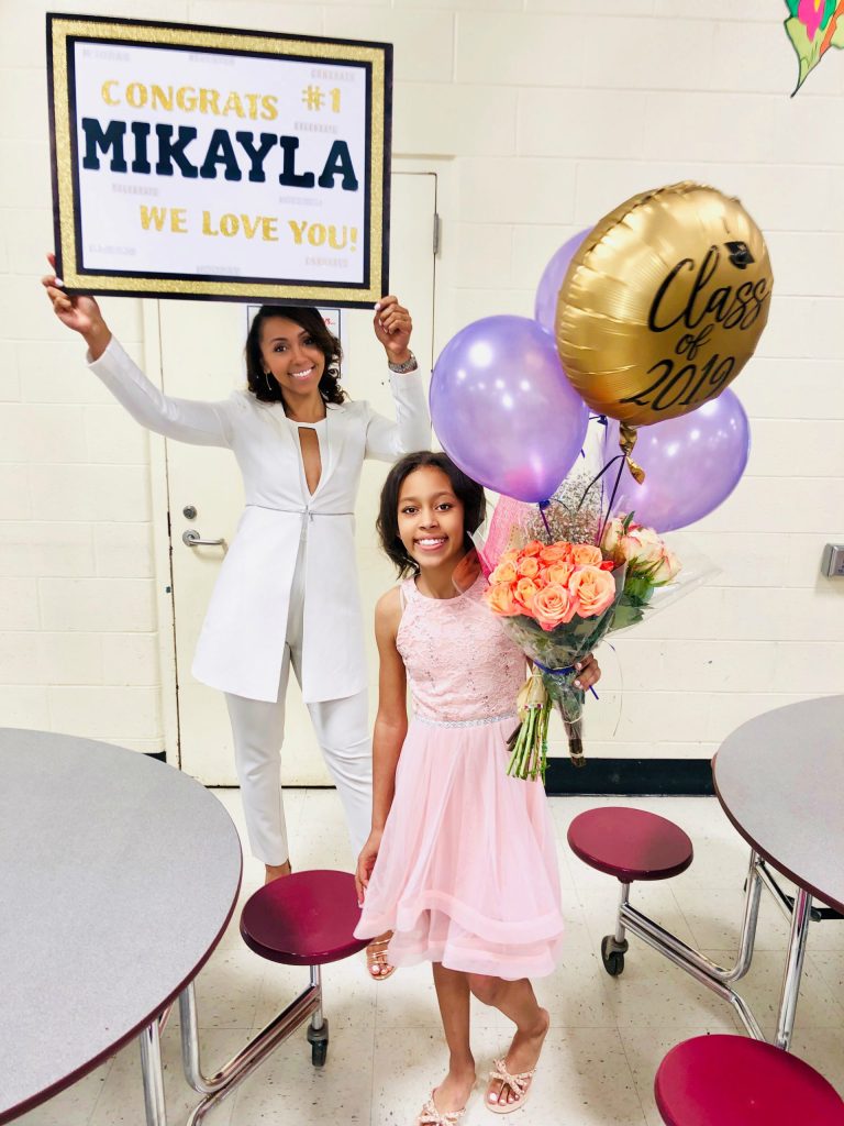 Demitrea holding up a sign with Mikayla holding balloons that say, "Class of 2019"