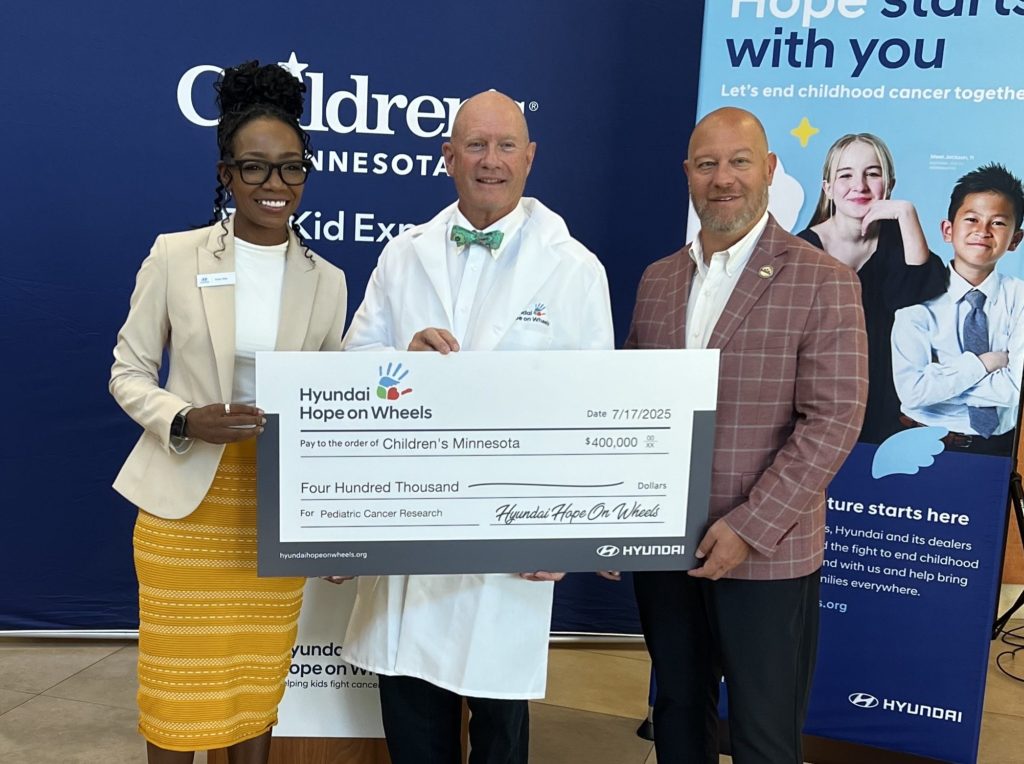 Dr. Stuart winter poses with two Hyundai representatives with a large check.