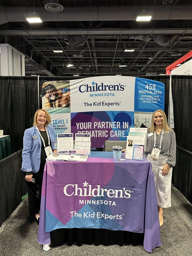 Two Children's Minnesota employees at the booth at the AAP conference.