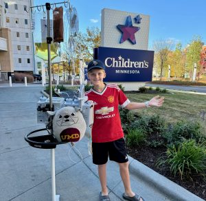 Asa stands outside the hospital smiling.