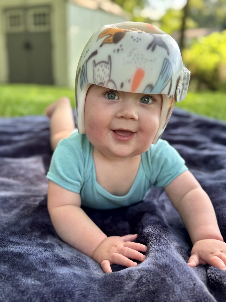 Baby with helmet smiling at the camera
