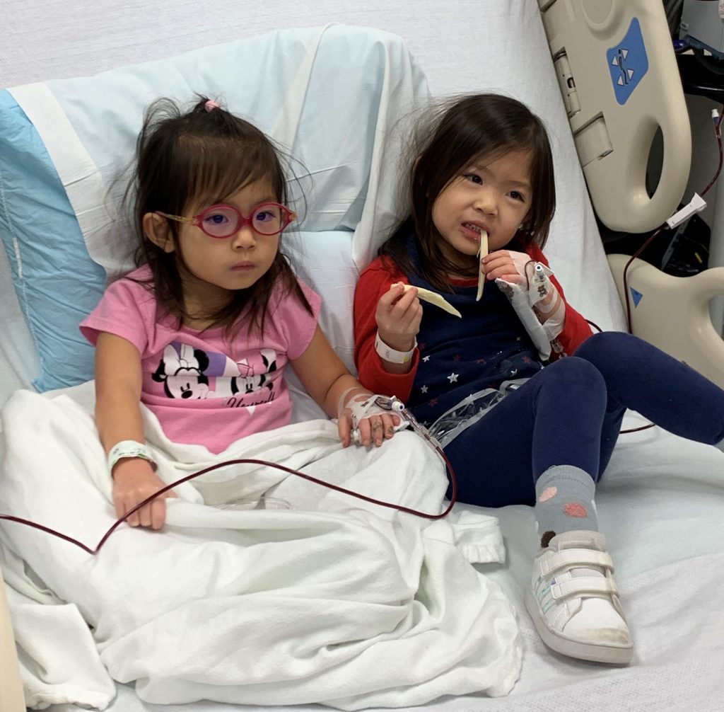 Isla and Eden in a hospital bed smiling together