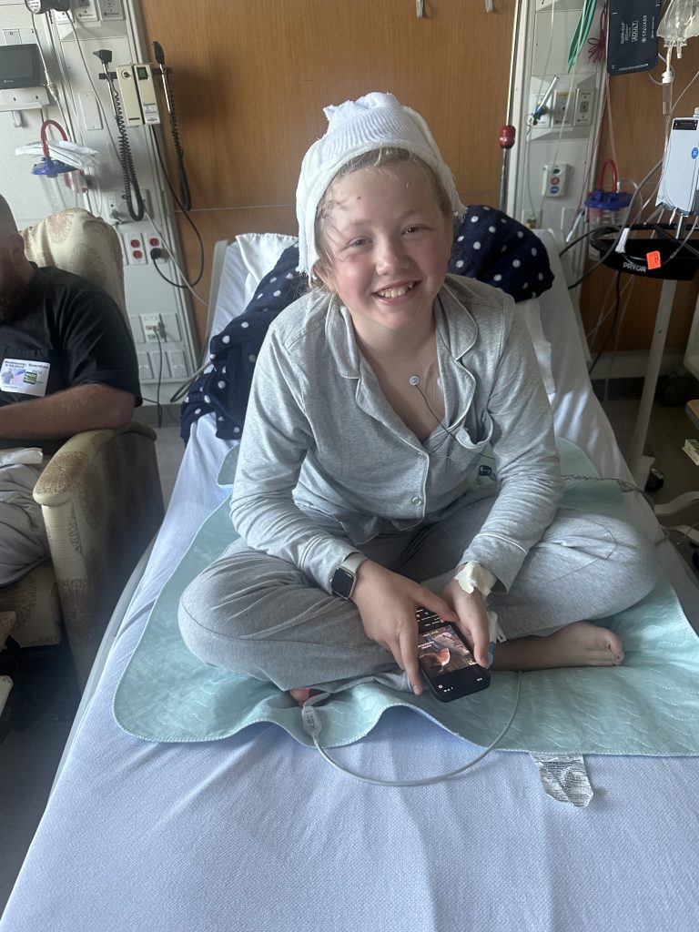 Amelia Ganun sitting in a hospital bed.