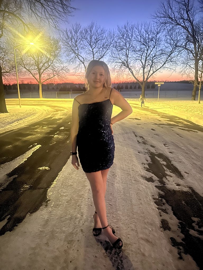 Amelia wearing a dress on a snow covered road/