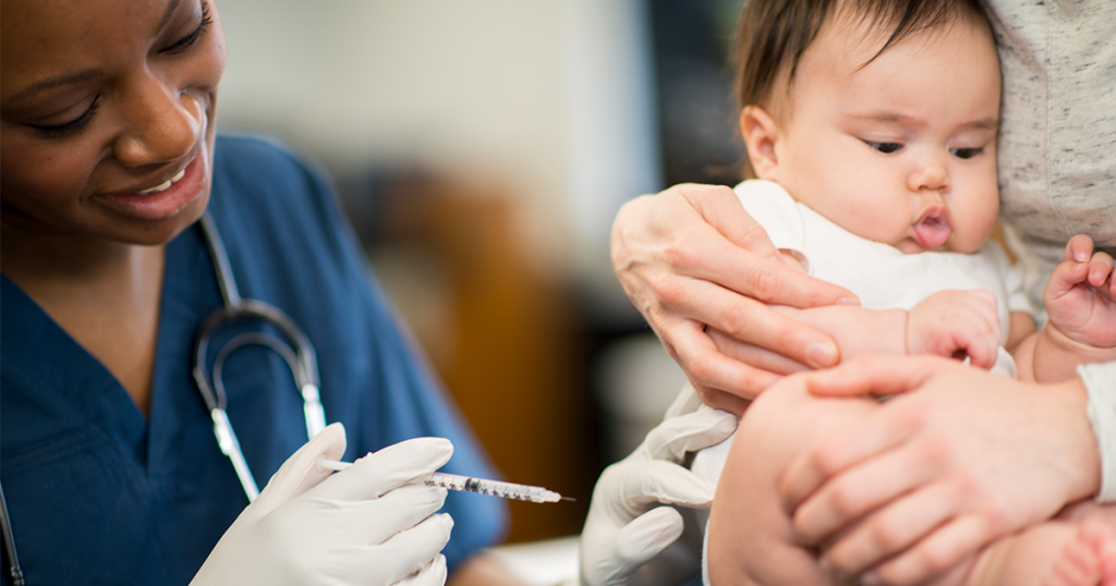 An Infant getting vaccinated while sitting in mother's lap