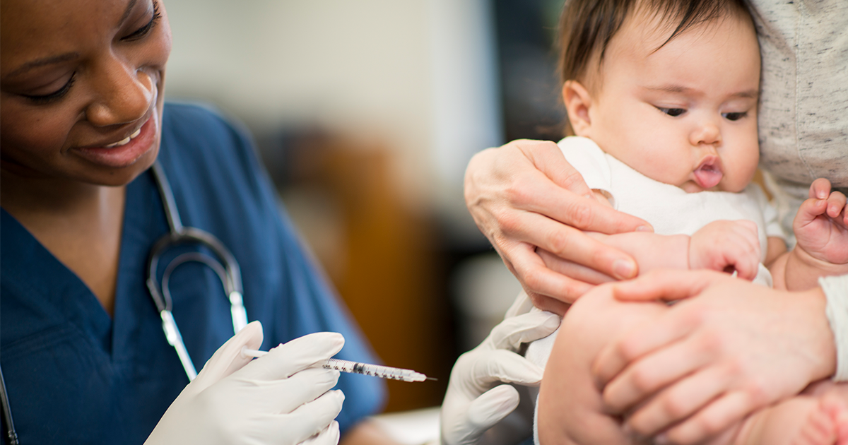 Infant getting vaccination while sitting in mother's lap