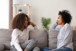 Mom and daughter sitting on the couch talking