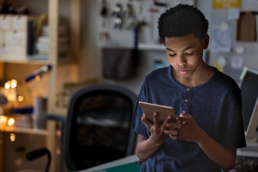 Teen boy on tablet in his room