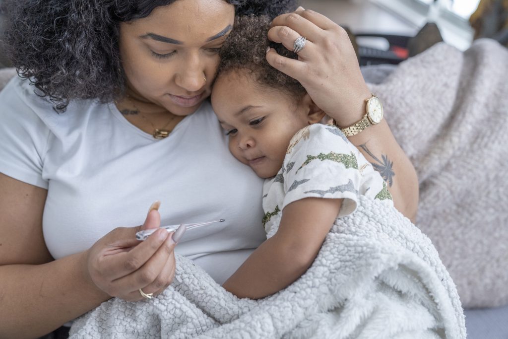 Mom snuggling sick child