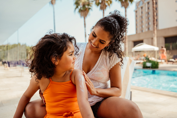 Mother putting sunscreen on daughter