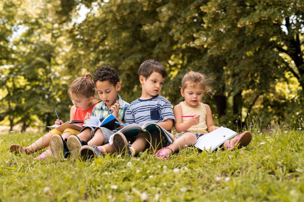 Kids reading in grass