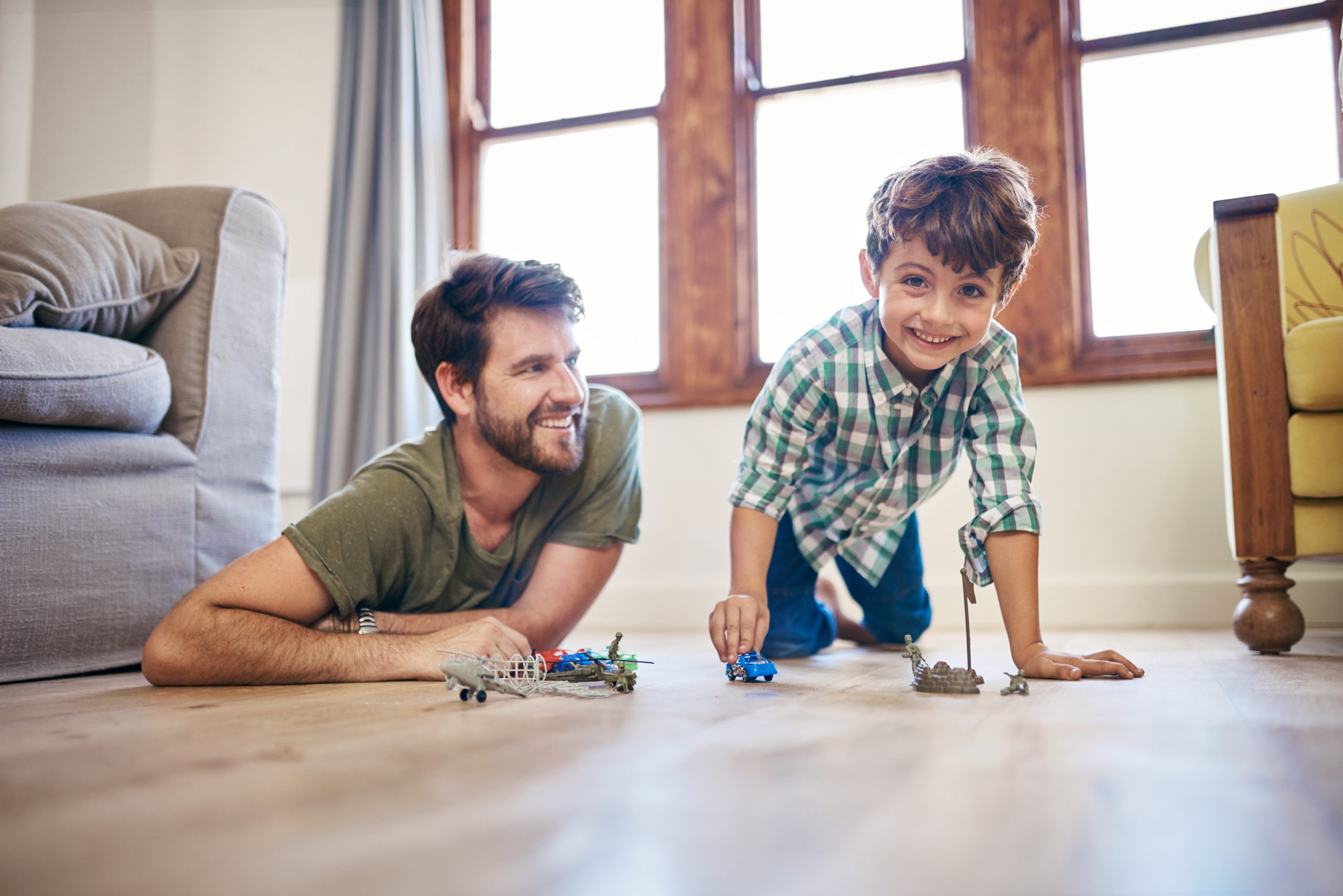 Dad and boy playing with toys on the ground
