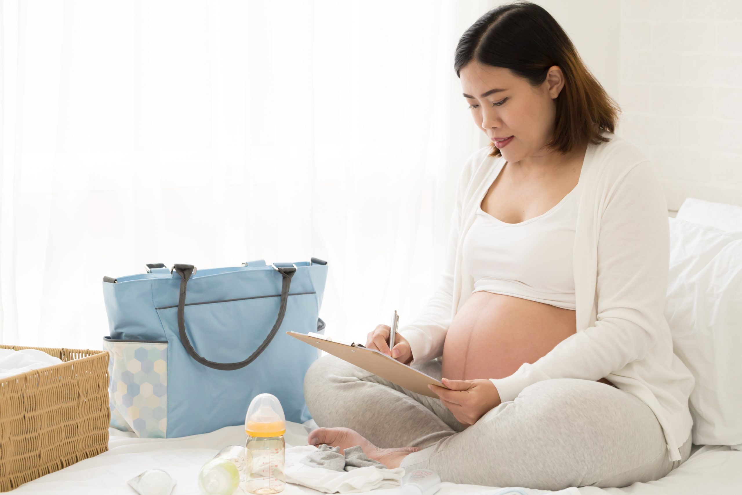 Pregnant person making a packing list for the hospital