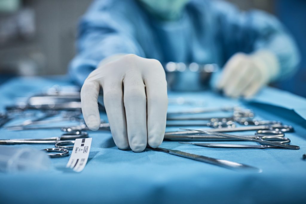 Surgeon picking a tool from a surgical tray