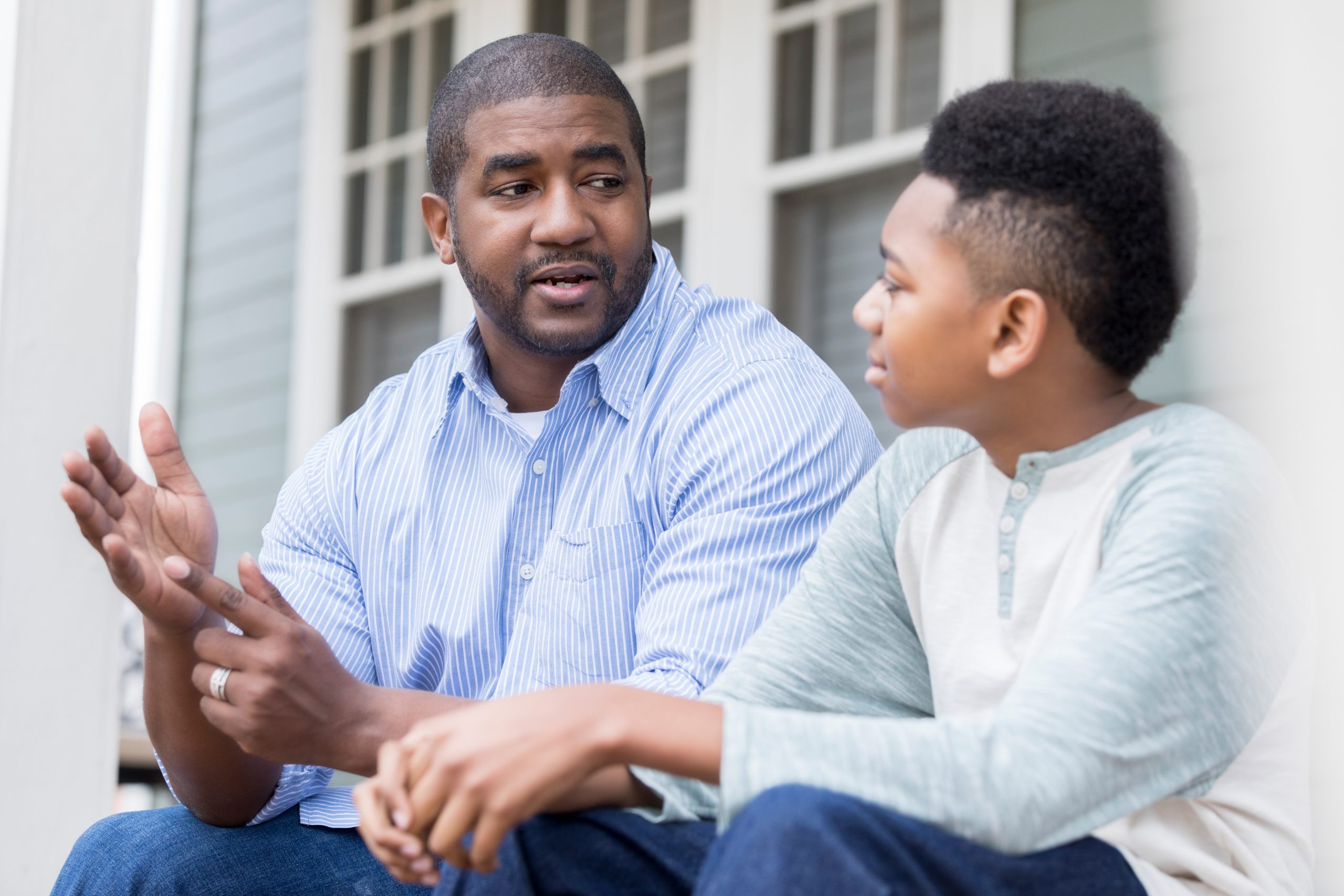 a father and son sit and talk to each other