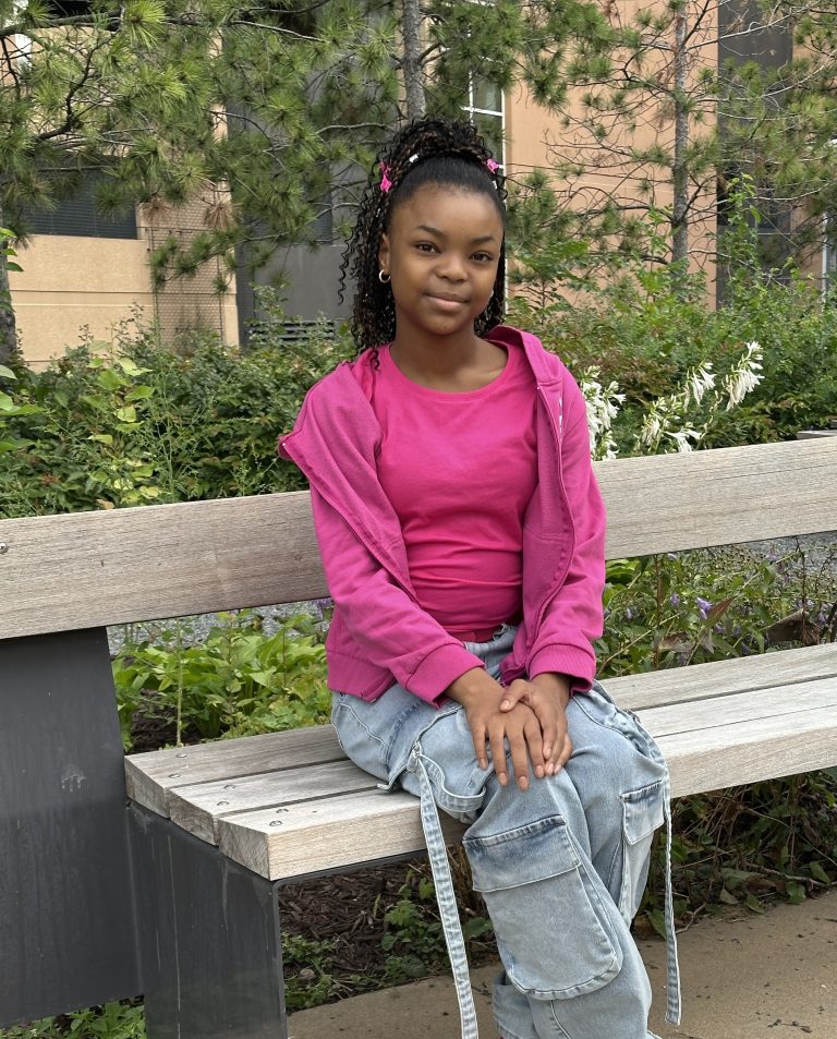 preteen girl wearing a pink shirt and jeans.