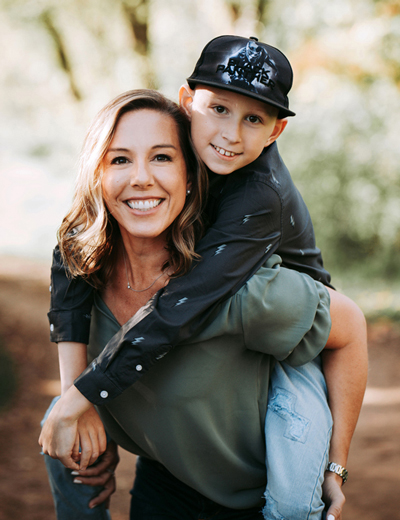 Smiling mom with child on her back