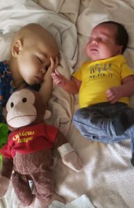 Junior in his hospital bed at Children's Minnesota with is baby brother DaVinci lying next to him.