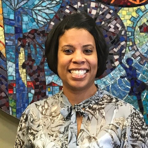 Keisha Powell, director of equity and inclusion at Children’s Minnesota, pictured in front of a colorful mosaic.