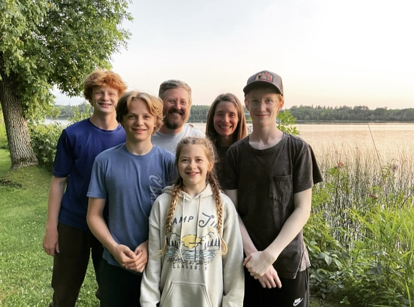 Photo of Lincoln with his parents and siblings in front of a lake while on vacation.