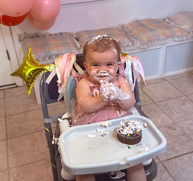 Lucy smashing and eating her first birthday cake