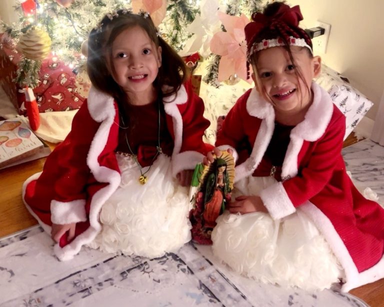 Luna and Sol sitting in front of a Christmas tree.