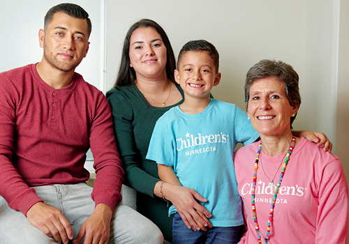 Mateo posing with his dad, mom and Children's Minnesota staff