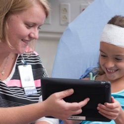 Child Life specialist uses iPad to help distract patient from procedures.