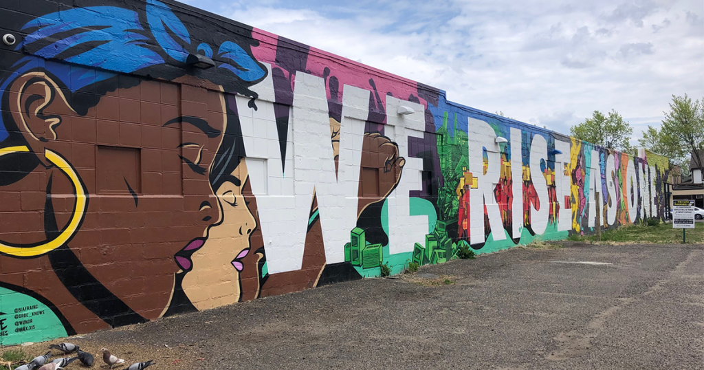 A mural that says "We rise as one" in Minneapolis