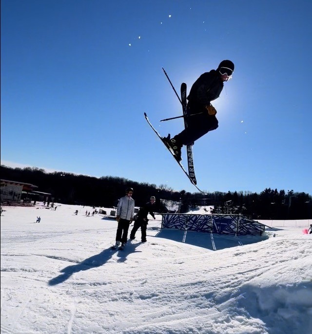 Photo of Matty skiing with friends on a sunny day.