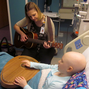 Music therapist playing music for a patient