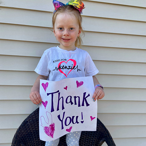 Kenzie saying thank you for donating with a sign