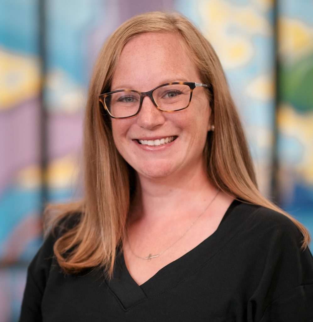 Dr. Megan Paulsen smiles in a black top and glasses.