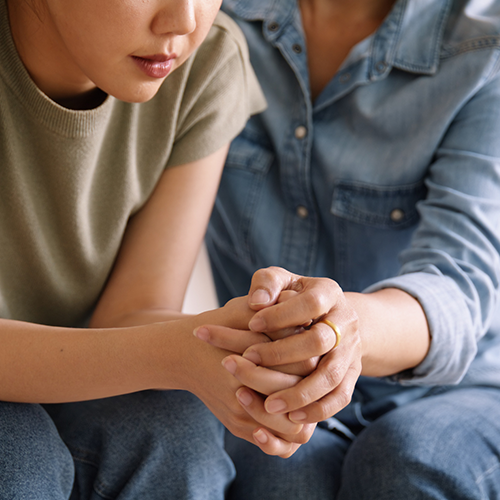 mother and daughter talking seriously about mental health on the couch