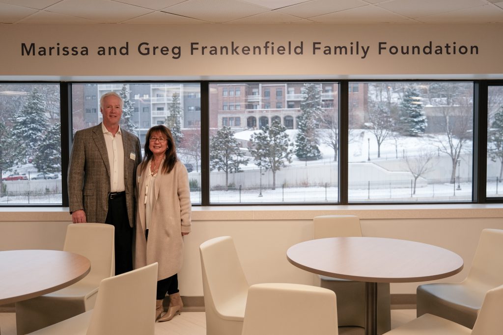 Two adults stand near a sign that says Marissa and Greg Frankenfield Family Foundation