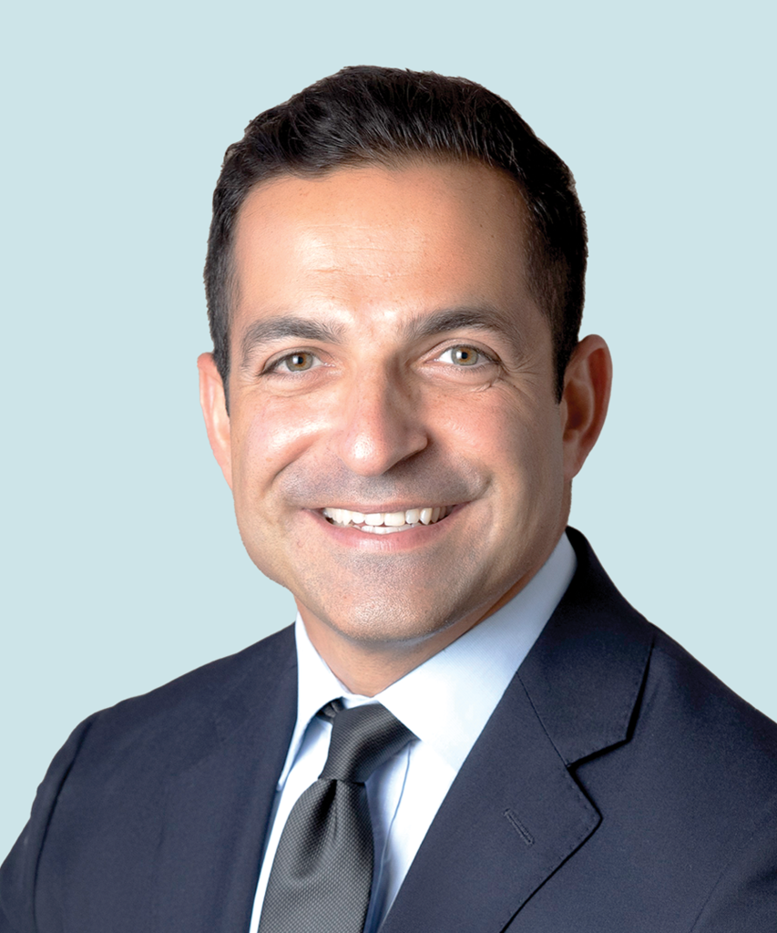 Meysam Kebriaei smiles in a navy suite and tie.