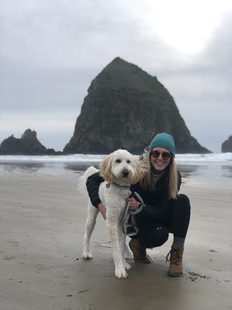 Brianna Albrecht, physical therapist, on a beach with her dog.
