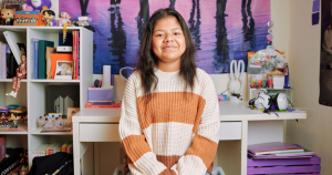 Neli sitting in her room and smiling