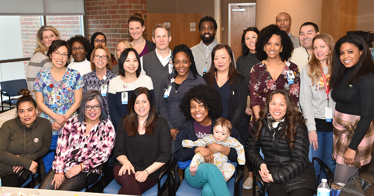 a group photo of 23 of Children's Minnesota nurses. The people in the photo are various races and genders.