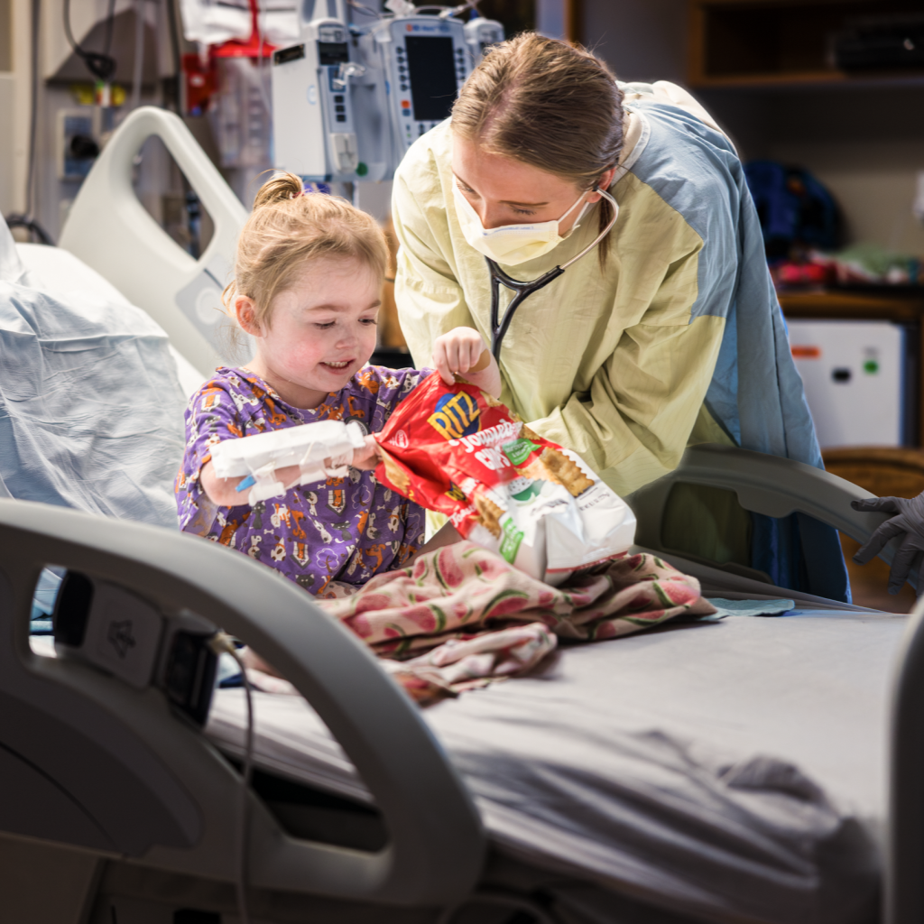 A nurse helping a child in a hospital bed.
