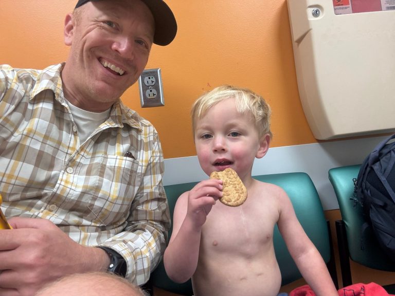 Ollie eating a cookie alongside his dad Josh.