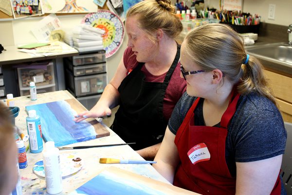 Two AYA teenagers painting at paint night