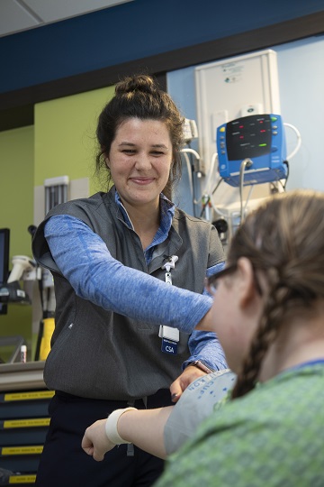 CSA taking blood pressure of teenage girl patient