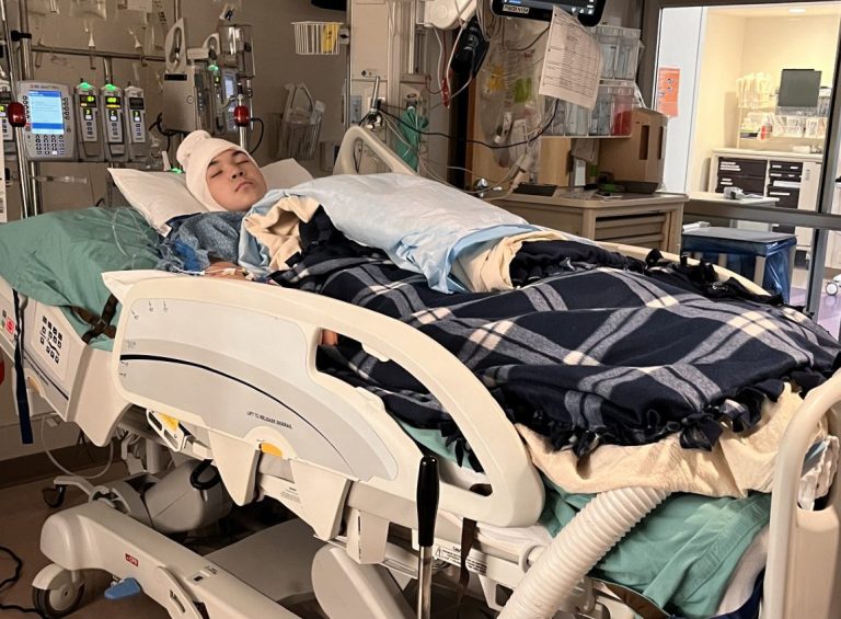 Peter sleeping in hospital bed.